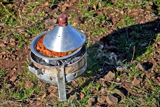 A steaming Moroccan tagine cooking outdoors on a portable stove in Fès.