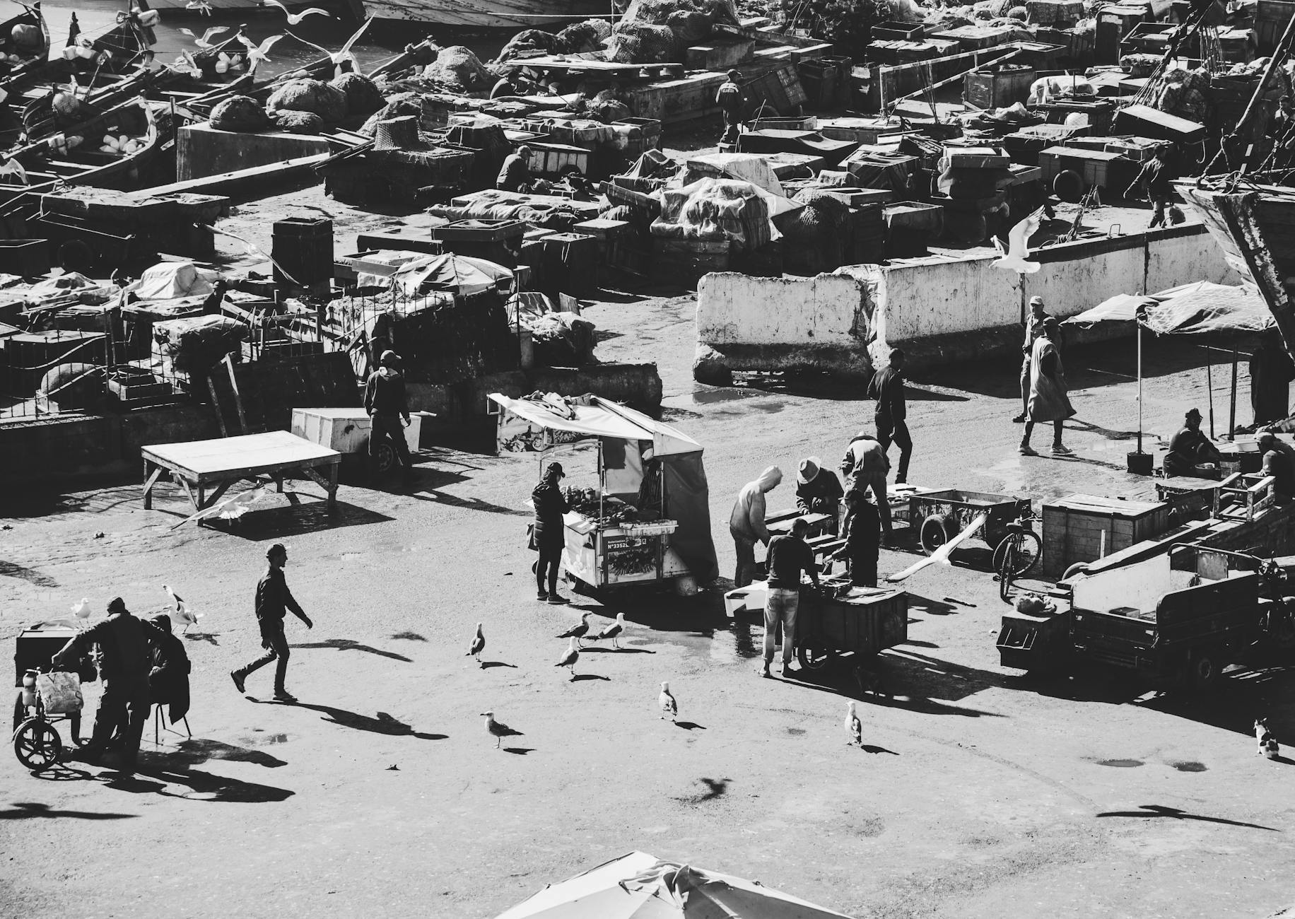 Black and white aerial view of bustling fishing market in Essaouira, Morocco.