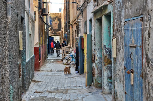 Historic Essaouira alleyway with colorful doors and local life in Morocco.