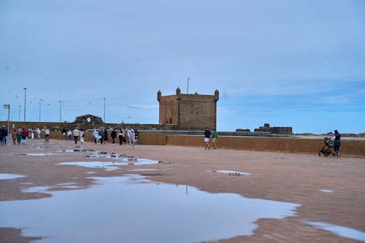 Scenic view of visitors at the historic Essaouira Fort in Morocco under a clear blue sky.