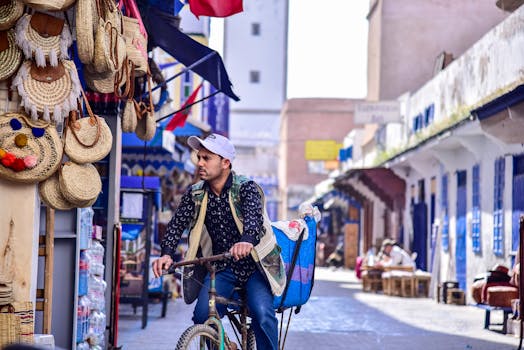 A man on a bicycle in the lively market streets of Essaouira, Morocco.