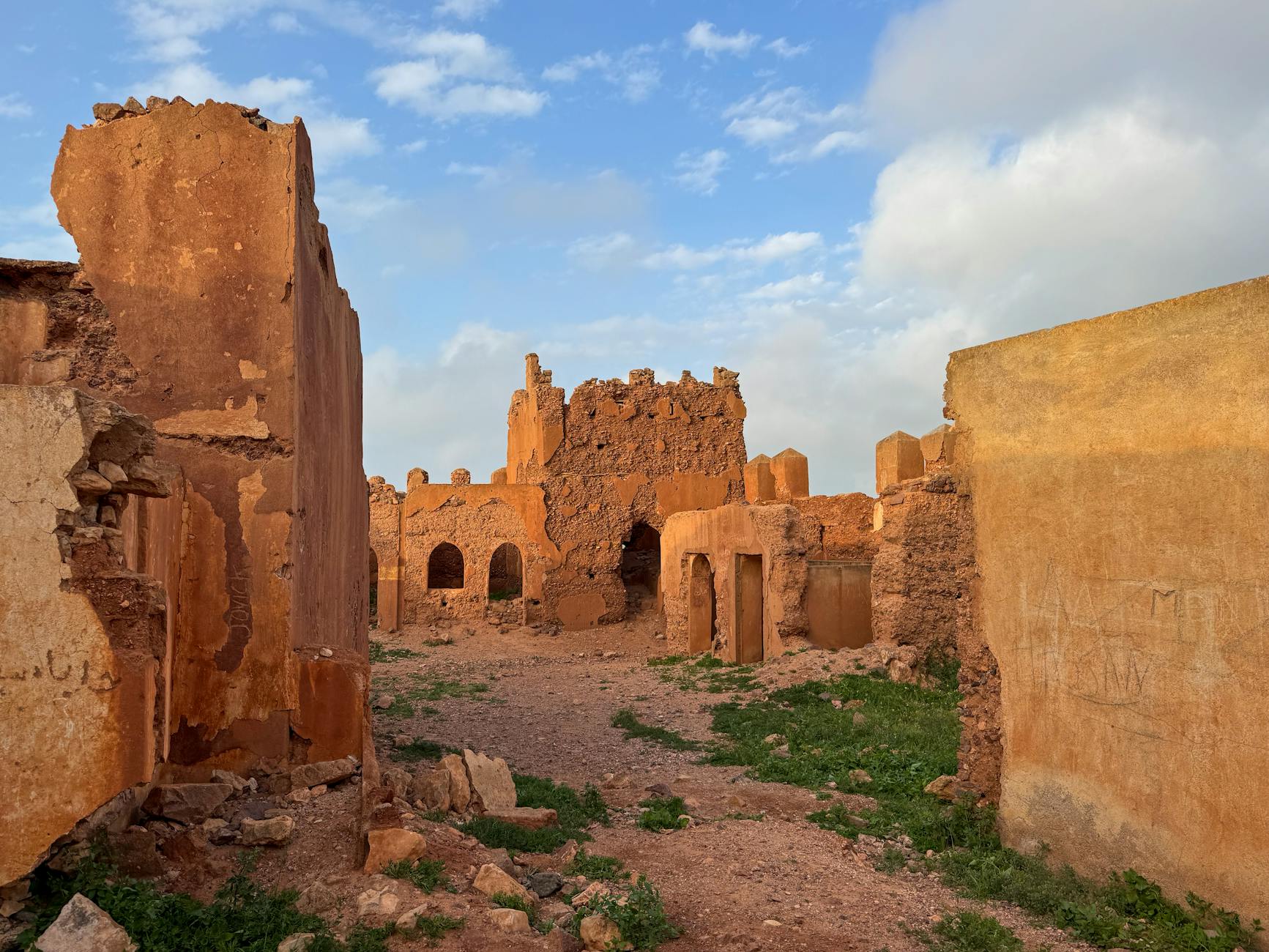Explore the ancient ruins of Mirleft, Morocco under a vibrant sunset sky.